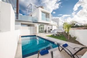 a villa with a swimming pool and a house at Olivine Pearl Villas in Protaras