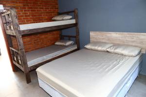 two bunk beds sitting next to a brick wall at Morada da Plataforma Tramandaí in Tramandaí