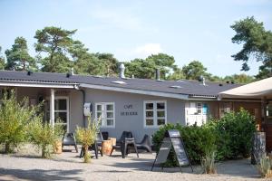 a building with chairs in front of it at Dueodde Hostel in Neksø