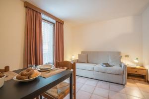 un soggiorno con divano e tavolo di Residence Fior d'Alpe a Bormio