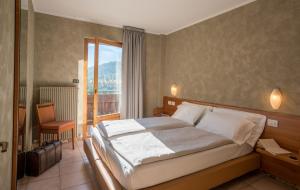 una camera con un grande letto e un balcone di Residence Fior d'Alpe a Bormio