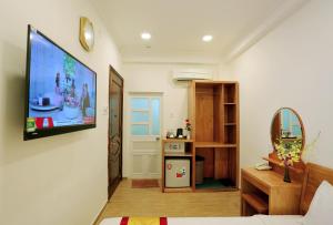 a living room with a large flat screen tv on the wall at CR Hotel in Nha Trang