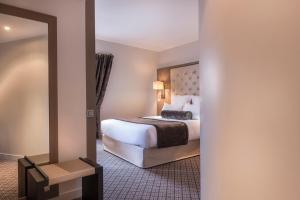 um quarto de hotel com uma cama e um espelho em La Villa des Ternes em Paris