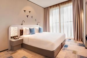 a bedroom with a large bed with birds on the wall at Lemon Tree Hotel, Jumeirah Dubai in Dubai