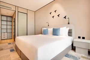 a bedroom with a bed with birds on the wall at Lemon Tree Hotel, Jumeirah Dubai in Dubai