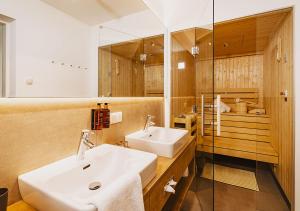 a bathroom with a sink and a mirror at Elements Resort Zell am See; BW Signature Collection in Zell am See