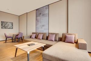 a living room with a couch and a table at Lemon Tree Hotel, Jumeirah Dubai in Dubai