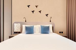 a bedroom with a bed with birds on the wall at Lemon Tree Hotel, Jumeirah Dubai in Dubai
