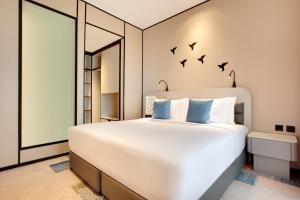 a bedroom with a bed with birds on the wall at Lemon Tree Hotel, Jumeirah Dubai in Dubai