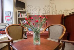 プラハにあるホテル プロコプカの椅子2脚付きテーブルの上に飾られた赤い花瓶