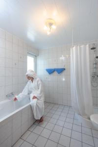 a woman in a bath tub in a bathroom at Boardinghouse Gladbeck in Gladbeck