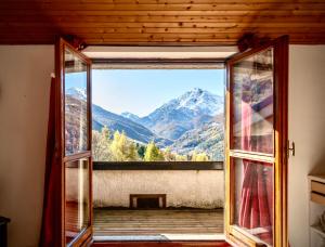 an open window with a view of mountains at Mountain Apartment in Sauze dʼOulx