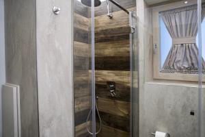 a bathroom with a shower with a wooden wall at OGGI e DOMANI in Naples +23 photos