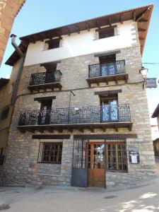 duży kamienny budynek z balkonem w obiekcie El Refugio Valdelinares Gastro Hostal w mieście Valdelinares