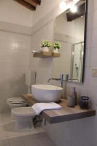 a bathroom with a sink and a toilet and a mirror at Borgo Cortinova Marrocco in Rapolano Terme