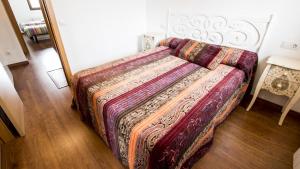 a bed in a room with a blanket on it at Casa Rural Galana in La Puebla de Valverde