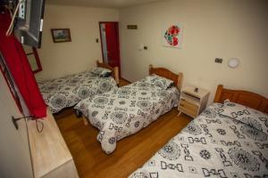 Dos camas individuales en una habitación con suelo de madera. en Residencial la Cabaña, en Santiago 47 fotos más