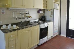 a kitchen with yellow cabinets and a sink and a stove at Apart Hotel Las Hadas Carilo in Carilo