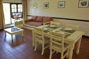 a living room with a table and chairs and a couch at Apart Hotel Las Hadas Carilo in Carilo