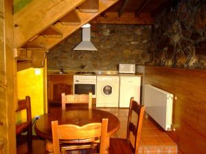 a kitchen with a table and a stove and a microwave at Las Casucas de Ason in Arredondo