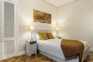 um quarto branco com uma cama e 2 candeeiros em BNBHolder Love Madrid PLAZA DE ESPAÑA em Madri