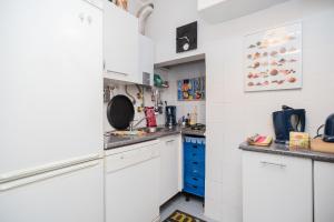 リスボンにあるRoux - 28455ALの白いキャビネットと青い引き出し付きのキッチンが備わります。