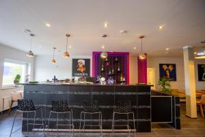 eine Bar in einem Restaurant mit Stühlen drum herum in der Unterkunft Confour Hotel in Burgdorf
