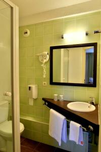 a bathroom with a sink and a mirror and a toilet at Hôtel Inn Chambéry in La Ravoire