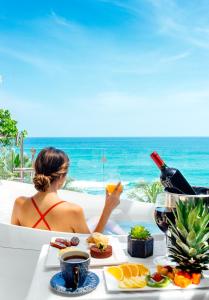a woman sitting at a table with a glass of wine at Garten Hotel in El Zonte