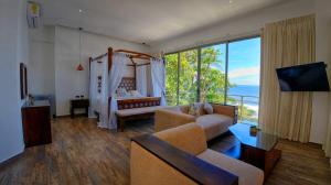 a living room with a couch and a large window at Garten Hotel in El Zonte