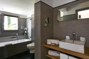 a bathroom with a sink and a toilet and a mirror at Le Pinarello in Sainte-Lucie de Porto-Vecchio