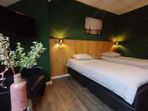 two beds in a room with green walls at Hotel Lemmenhof in Ell