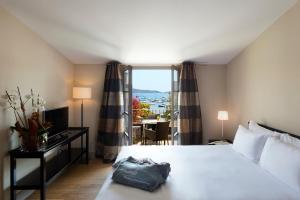 a hotel room with a large bed and a window at Le Pinarello in Sainte-Lucie de Porto-Vecchio
