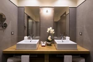 two sinks in a bathroom with two mirrors at Le Pinarello in Sainte-Lucie de Porto-Vecchio