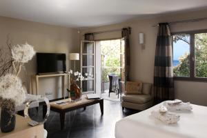 a living room with a bed and a couch and a table at Le Pinarello in Sainte-Lucie de Porto-Vecchio
