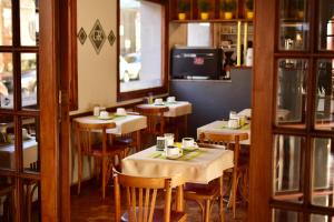 ein Restaurant mit Tischen und Stühlen in einem Raum in der Unterkunft Gran Rex Hotel in Cordoba
