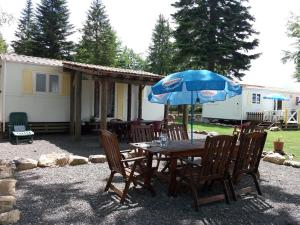 ChasseradèsLe SOUS BOIS DE JADE CHEMIN DE STEVENSON GR 70的一张木桌和椅子及雨伞
