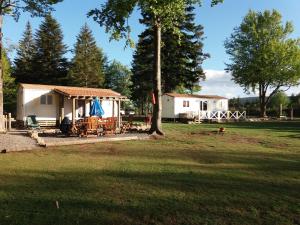 ChasseradèsLe SOUS BOIS DE JADE CHEMIN DE STEVENSON GR 70的庭院内带桌椅的白色小屋 更多38张照片