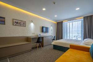 um quarto de hotel com uma cama e uma escrivaninha em Atrium Exclusive - Ski4Life em Gudauri