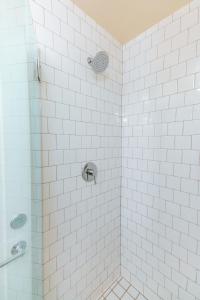 a bathroom with a shower with white tiles at Cache House in Jackson