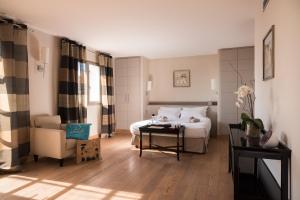 a bedroom with a bed and a chair and a table at Le Pinarello in Sainte-Lucie de Porto-Vecchio