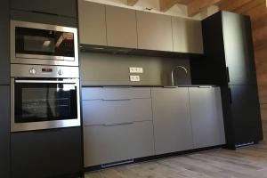 una cocina con electrodomésticos de acero inoxidable en una habitación en Les Maisons de la Glappaz, en Mégevette