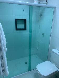 uma casa de banho com uma cabina de duche em vidro e um WC. em FLAT AMARÍLIS - RIVIERA DE SÃO LOURENÇo em Riviera de São Lourenço
