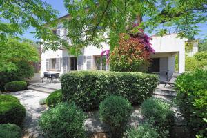 a house with a garden with bushes and trees at Le Pinarello in Sainte-Lucie de Porto-Vecchio