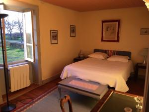 ein Schlafzimmer mit einem Bett und einem Tisch und einem Fenster in der Unterkunft Gite Renardière in Mons
