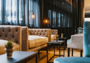 a living room with couches and tables and windows at The House Zell am See in Zell am See