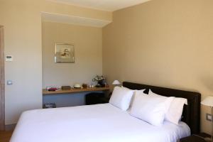 a hotel room with a bed with white pillows at Le Pinarello in Sainte-Lucie de Porto-Vecchio