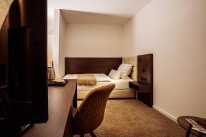 um quarto de hotel com uma cama e uma cadeira em Hotel Reckord em Herzebrock