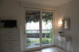 een kamer met een glazen schuifdeur en een televisie bij Trento View in Trento
