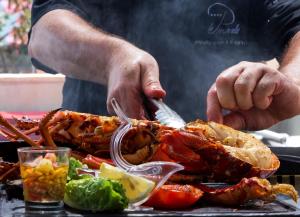 a person cutting up a lobster on a table at Le Pinarello in Sainte-Lucie de Porto-Vecchio